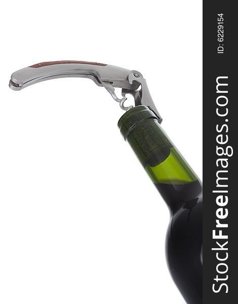 Opening wine bottle with a corkscrew on white background