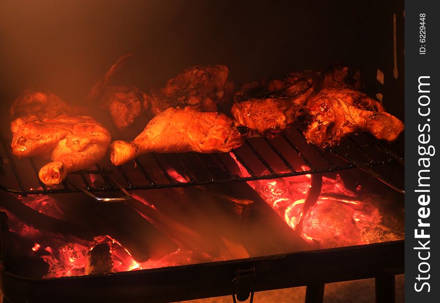 Chicken on a grill with smoke on left side