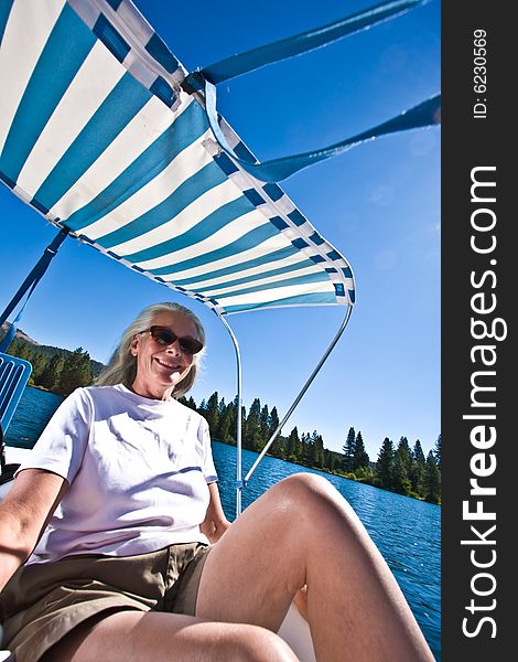 Senior woman in paddle boat on pond. Senior woman in paddle boat on pond