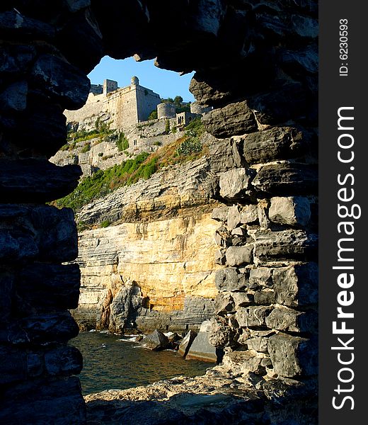 A suggestivbe shot of Doria castle in Porto Venere viewes by an ancient open window. A suggestivbe shot of Doria castle in Porto Venere viewes by an ancient open window