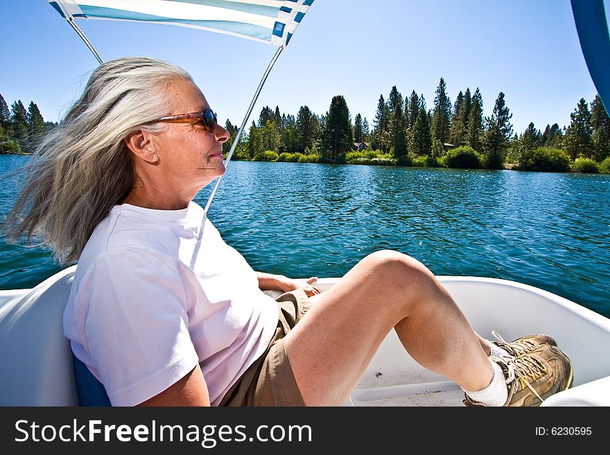 Senior woman in paddle boat on pond. Senior woman in paddle boat on pond