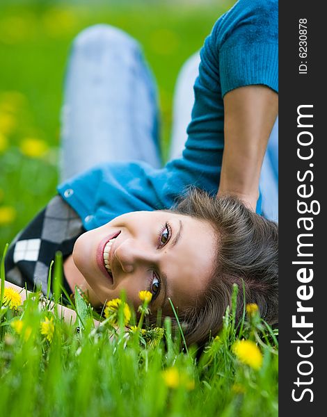 Nice girl is smiling on the field of dandelions. Nice girl is smiling on the field of dandelions