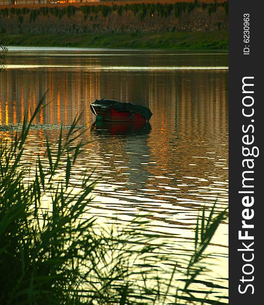 A wonderful shot of a boat on the Arno river at the sunset hour. A wonderful shot of a boat on the Arno river at the sunset hour