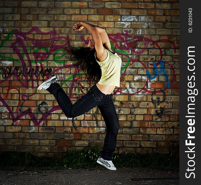 Young girl jumping against the wall. Young girl jumping against the wall.