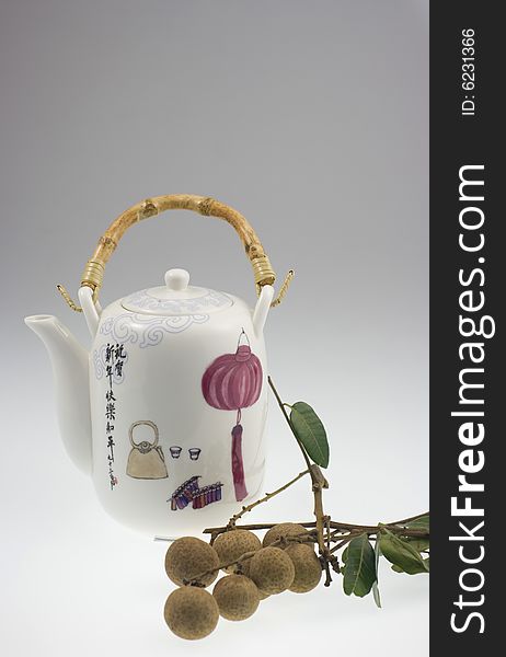 A Chinese pot with traditional Chinese painting and longan. A Chinese pot with traditional Chinese painting and longan