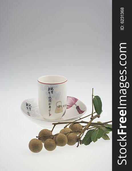 The chinese teacup with traditional Chinese painting and longan