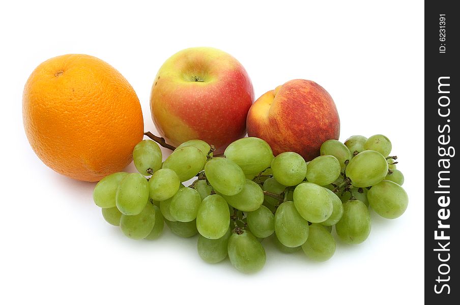 Green grapes in an environment of tasty fruit on a white background. Green grapes in an environment of tasty fruit on a white background