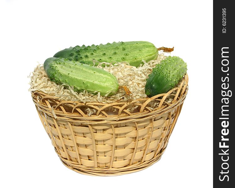 Green cucumbers in to a basket on a white background