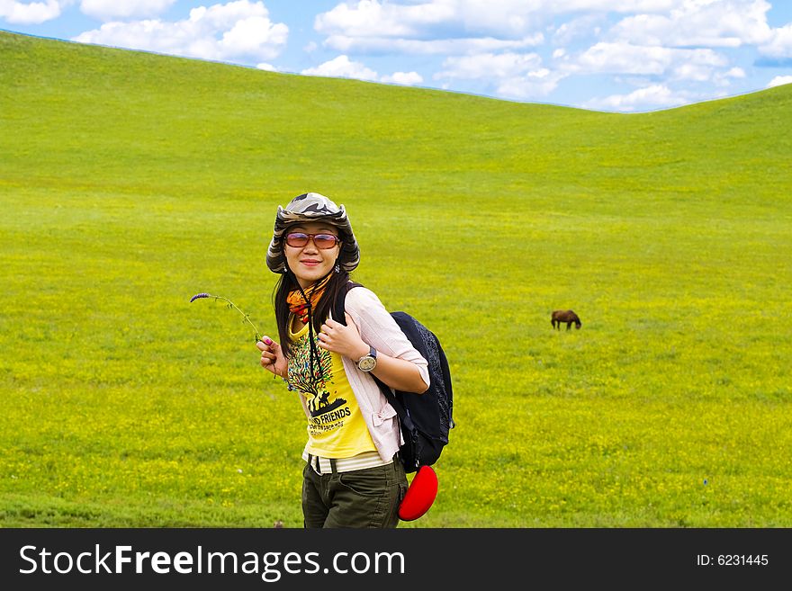 Happy girl on meadow against the blue sky and clouds