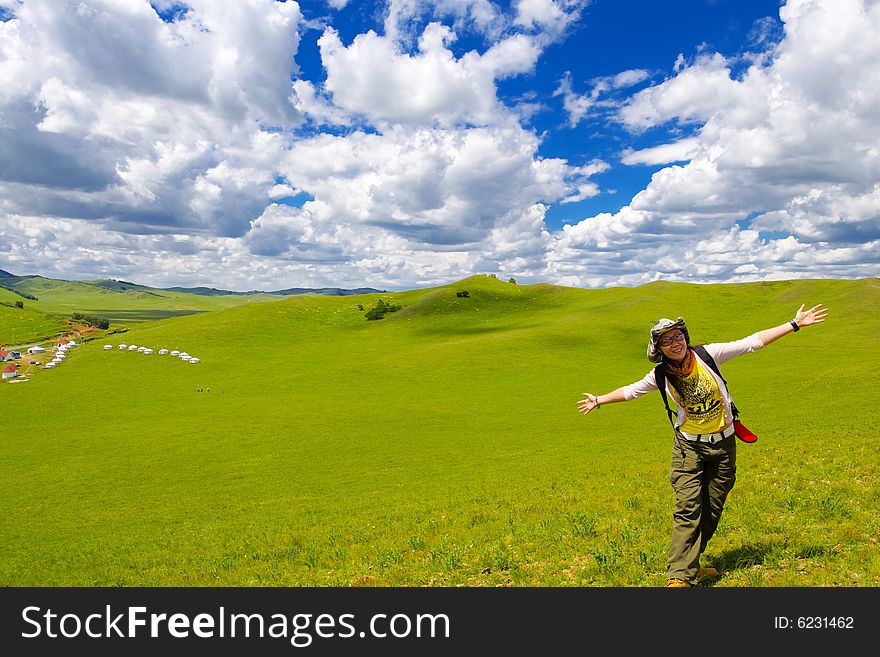 Happy girl on meadow against the blue sky and clouds. Happy girl on meadow against the blue sky and clouds