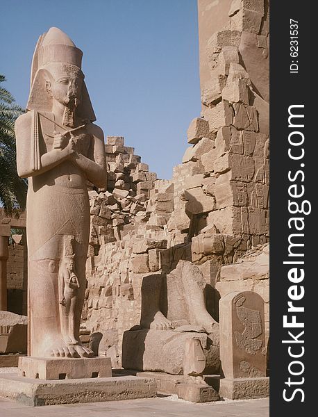 A colossus statue standing amongst the ruins of the Temples of Karnak in Luxor, Egypt. A colossus statue standing amongst the ruins of the Temples of Karnak in Luxor, Egypt.