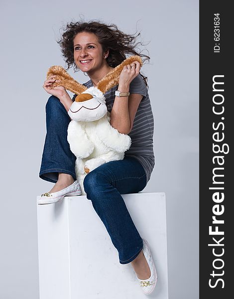 Smiling girl is sitting with a toy puppy. Smiling girl is sitting with a toy puppy