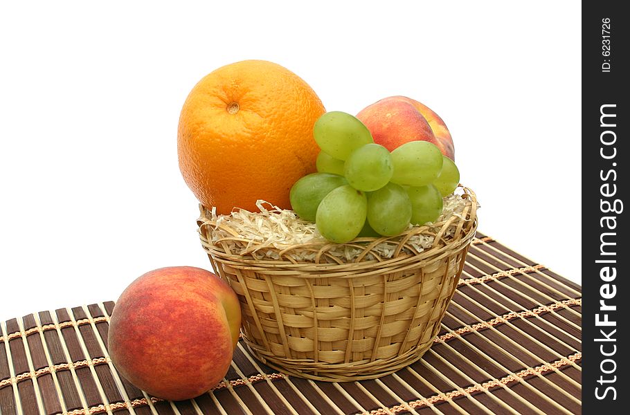 Peaches and orange in a yellow basket. Peaches and orange in a yellow basket