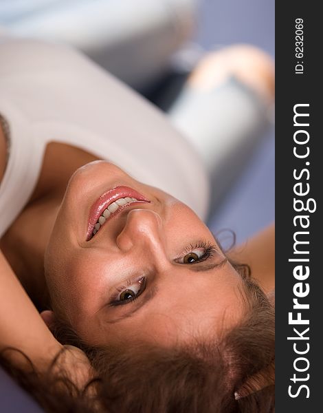 Brunette is lying on the floor and smiling. Brunette is lying on the floor and smiling