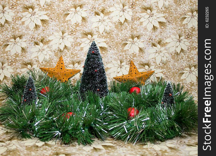 Lovely Christmas scene with a gold and white poinsettia background, green and silver tinsel, christmas trees, red balls, and gold/brass stars.