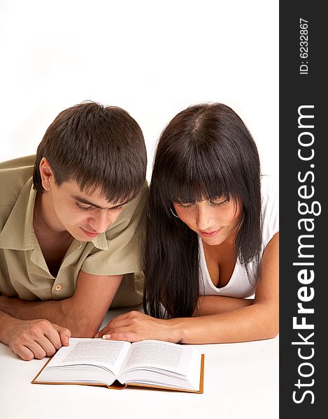 The young pair reads the book on a white background. The young pair reads the book on a white background
