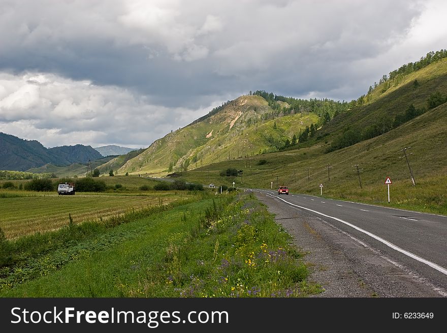 Asphalt road among mountains and low cloud sky. Asphalt road among mountains and low cloud sky