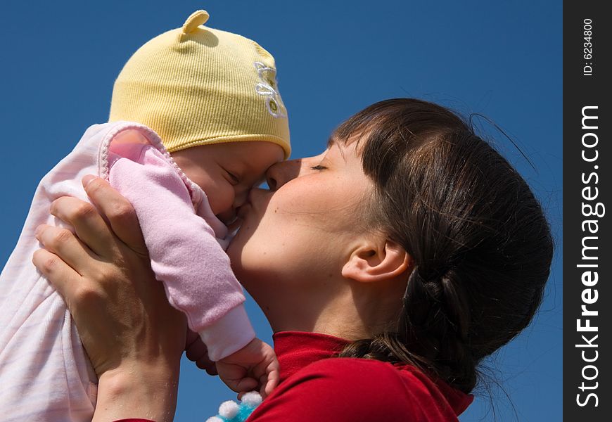 Baby with mom on blue sky background