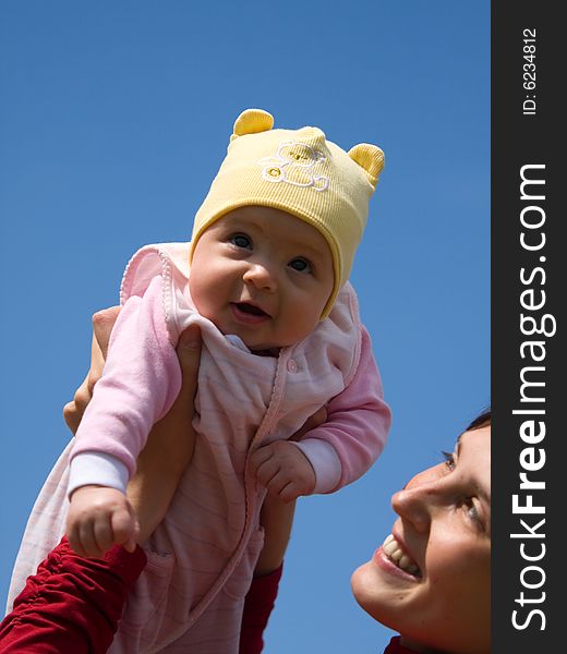 Baby with mom on blue sky background