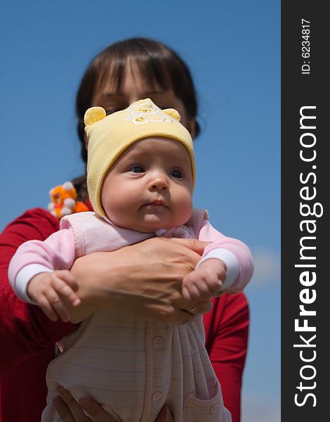 Baby with mom on blue sky background