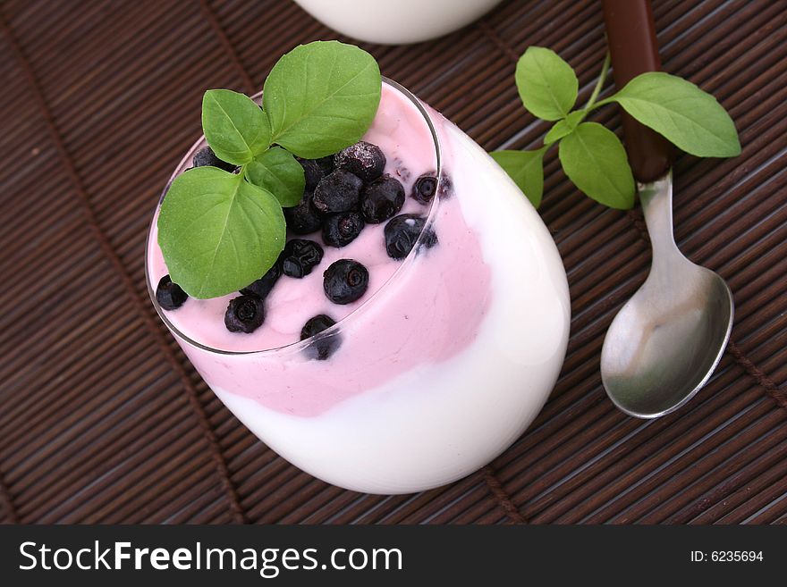 Blueberries in yogurt with green leaf