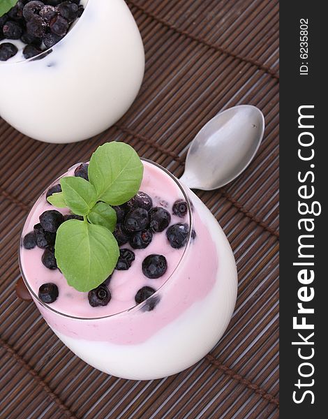 Blueberries in yogurt with green leaf