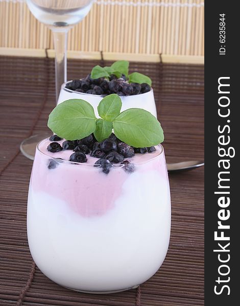 Blueberries in yogurt with green leaf