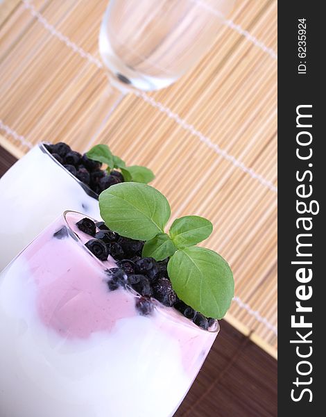 Blueberries in yogurt with green leaf