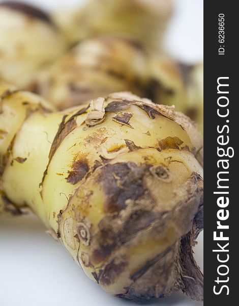 A stack of galangal root isolated against a white background