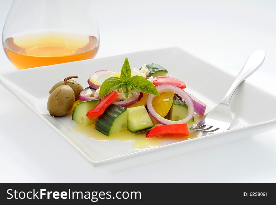 Delicious fresh greek salad with white wine.