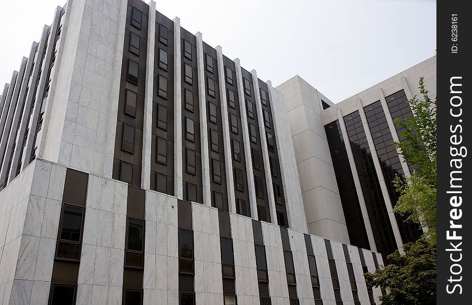 A modern white marble courthouse with black windows