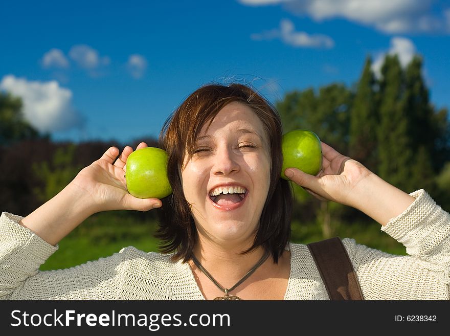 Woman with green apples by ears. Woman with green apples by ears