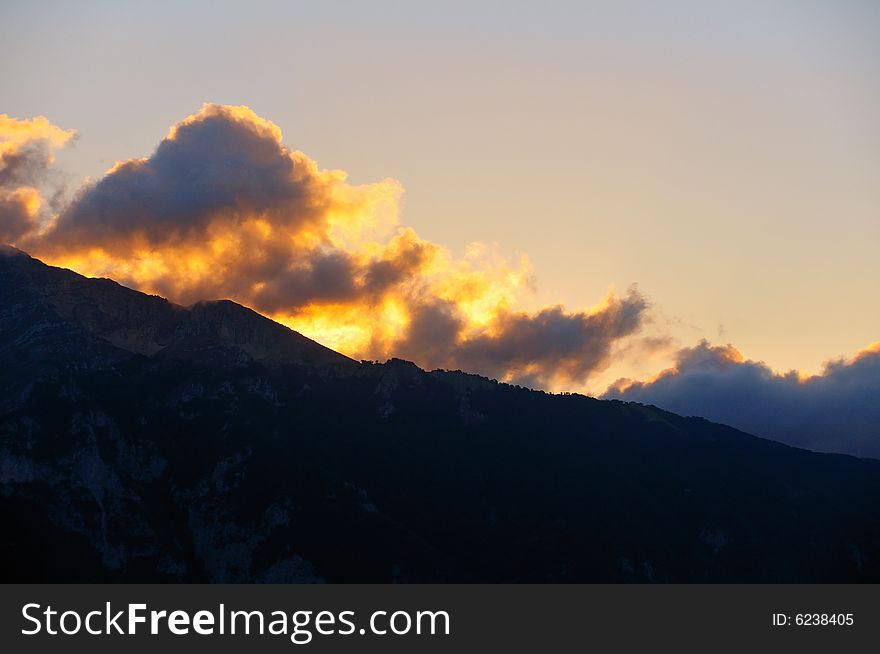 Sunset beneath the mountains with some tiny cumulus clouds. Sunset beneath the mountains with some tiny cumulus clouds