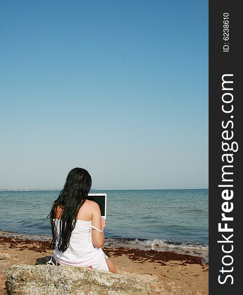 Girl on a beach with a notebook