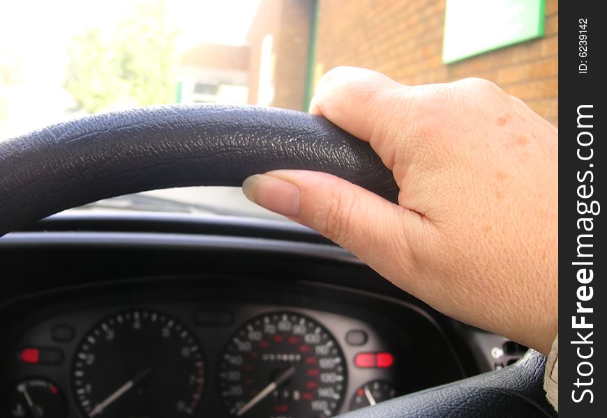 Hand on the steering wheel of a car. Hand on the steering wheel of a car