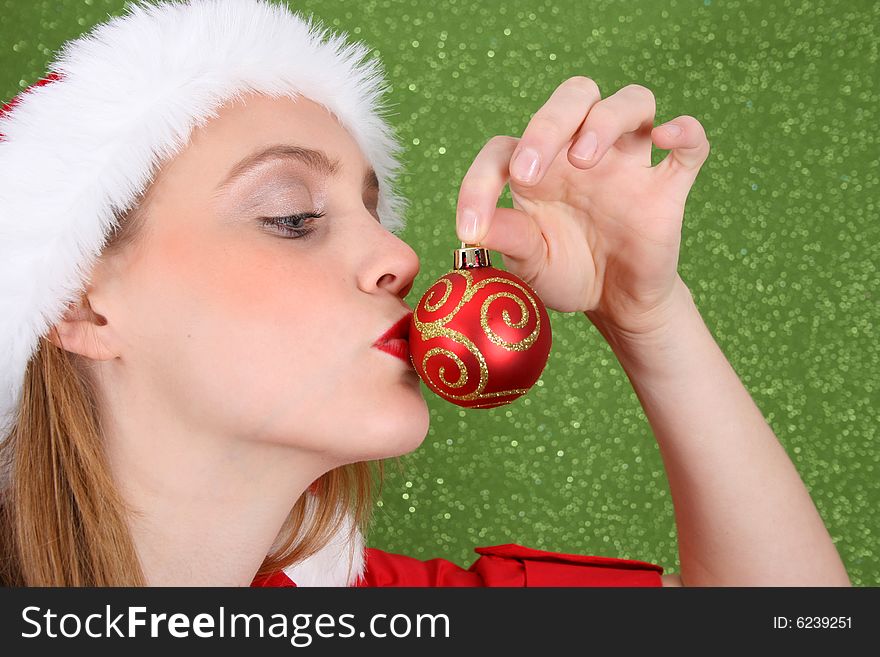 Christmas girl kissing a red and gold decoration. Christmas girl kissing a red and gold decoration