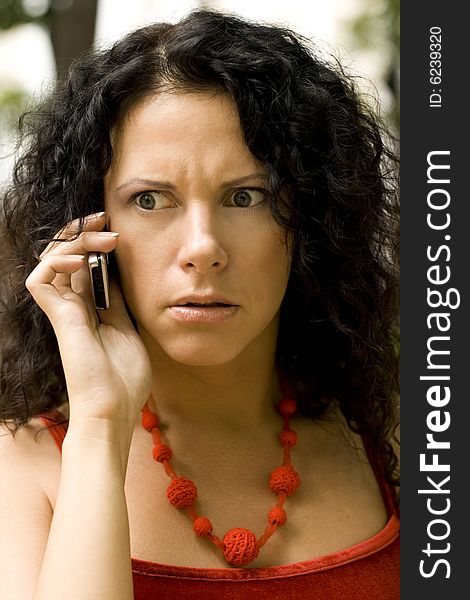 Outdoor portrait of woman on phone getting bad news