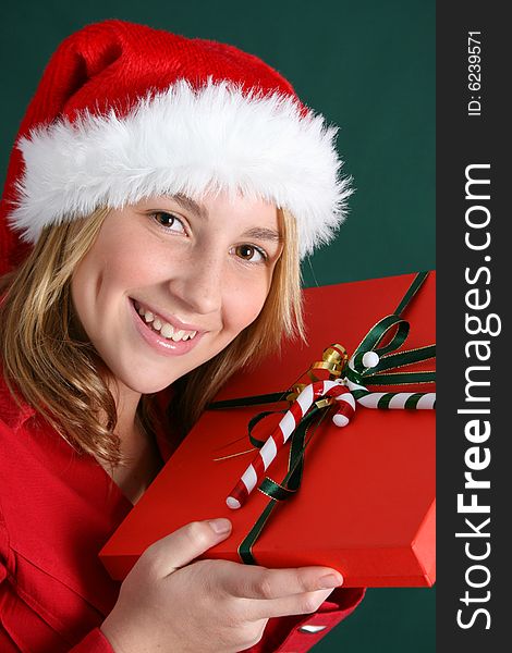 Teenager wearing a christmas hat, holding a present. Teenager wearing a christmas hat, holding a present