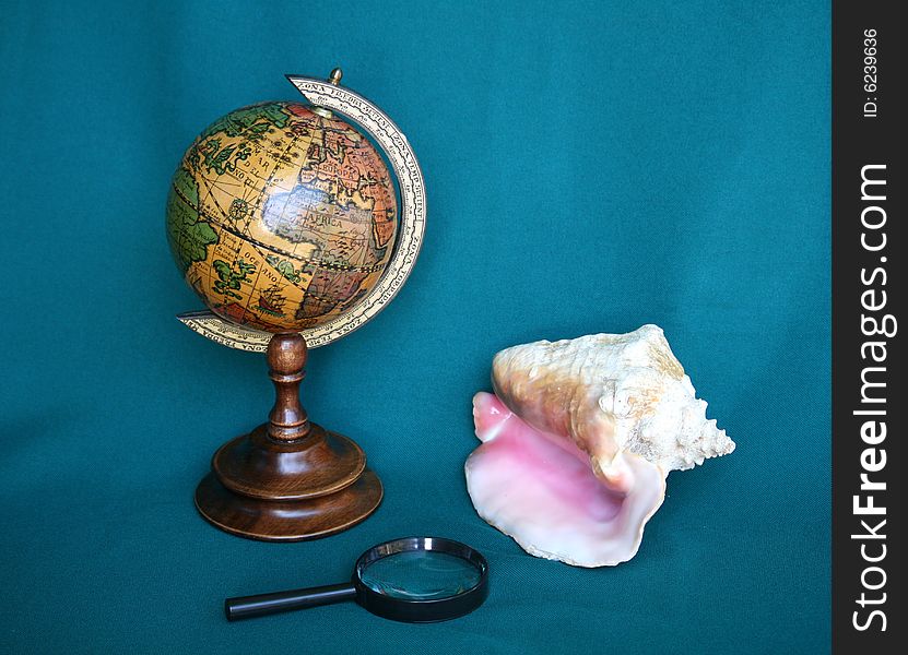 Still life with globe, shell and magnifying glass