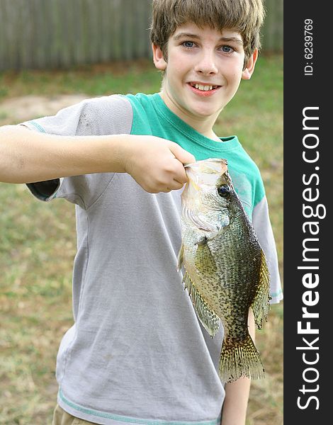 Young Boy Holding Fish He Caught