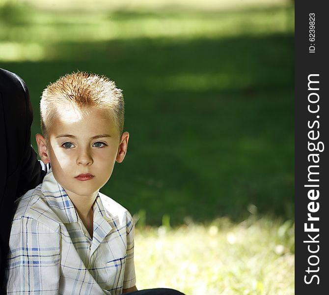 Young blond boy with blue eyes relaxing in the nature. Young blond boy with blue eyes relaxing in the nature