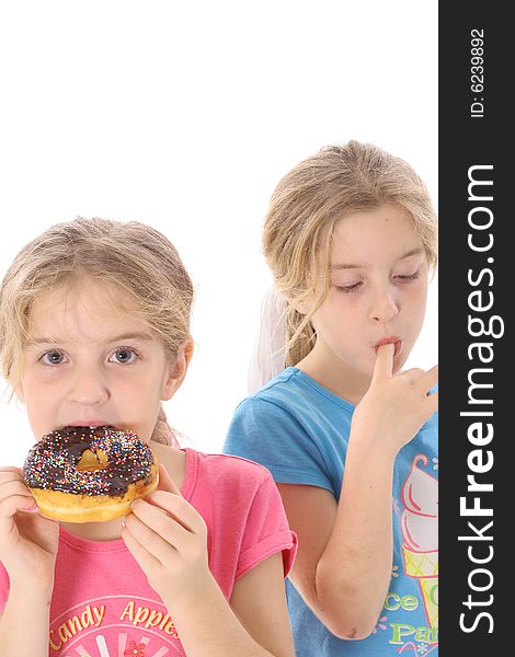 Twin sisters eating a doughnut vertical isolated on white