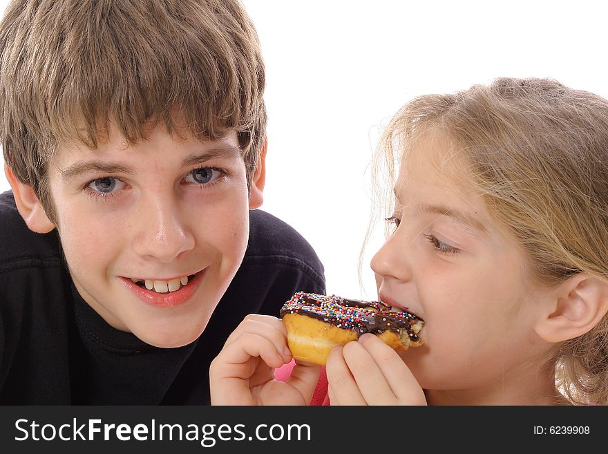 Brother and sister eating a doughnut isolated on white
