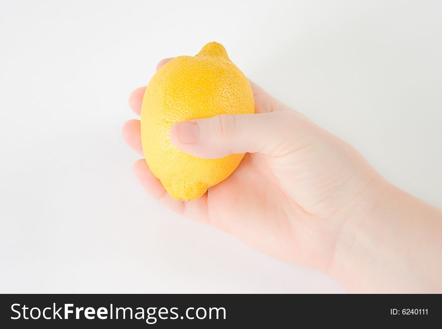 A lemon against a white background being held by a woman. A lemon against a white background being held by a woman