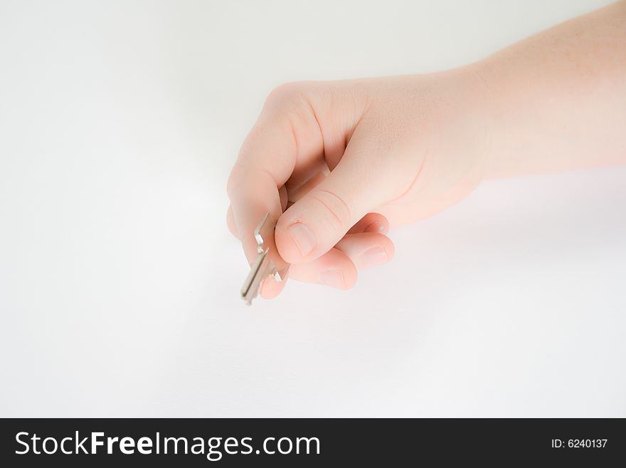 A hand holding a house key against a white background