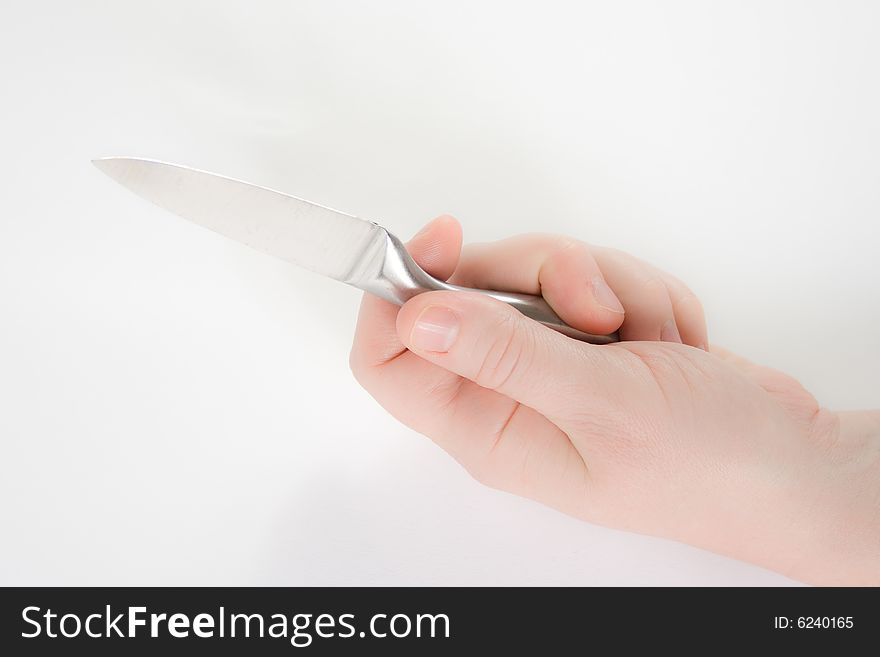 A hand holding a knife against a white background