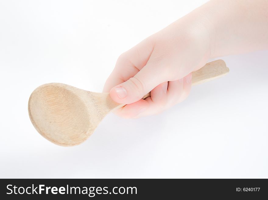 A hand holding a wooden spoon against a white background. A hand holding a wooden spoon against a white background