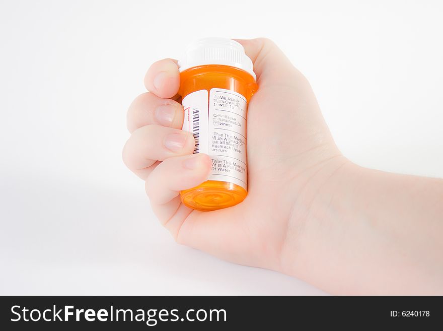 Hand holding a bottle of medicine against a white background. Hand holding a bottle of medicine against a white background