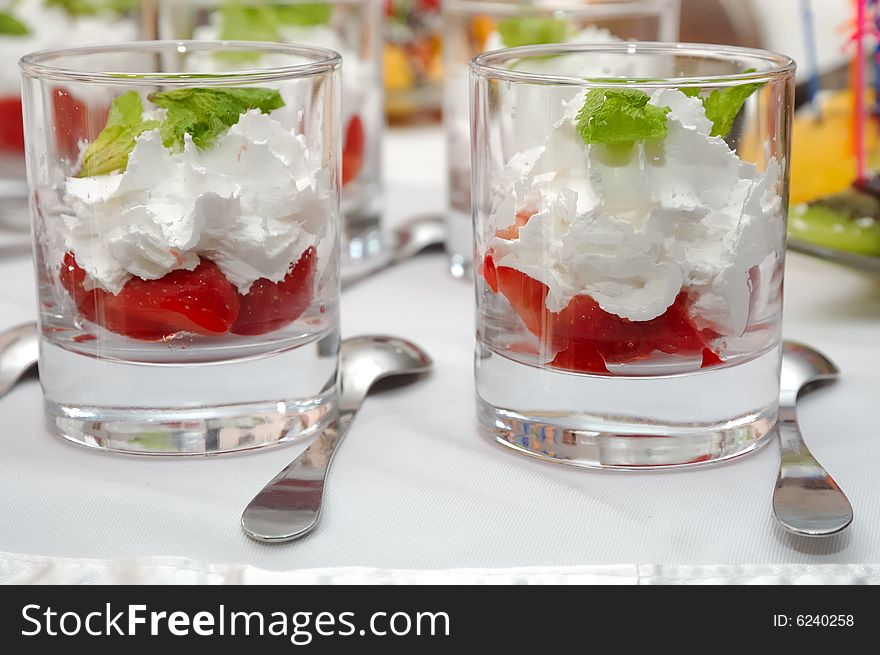 Sliced strawberries with cream and mint in glasses. Sliced strawberries with cream and mint in glasses
