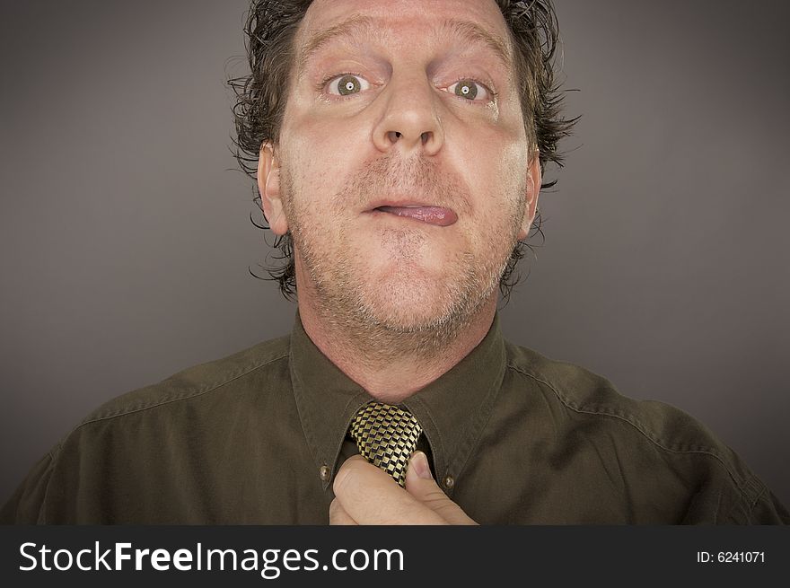 Man Concentrating Fixing Tie on a Grey Background